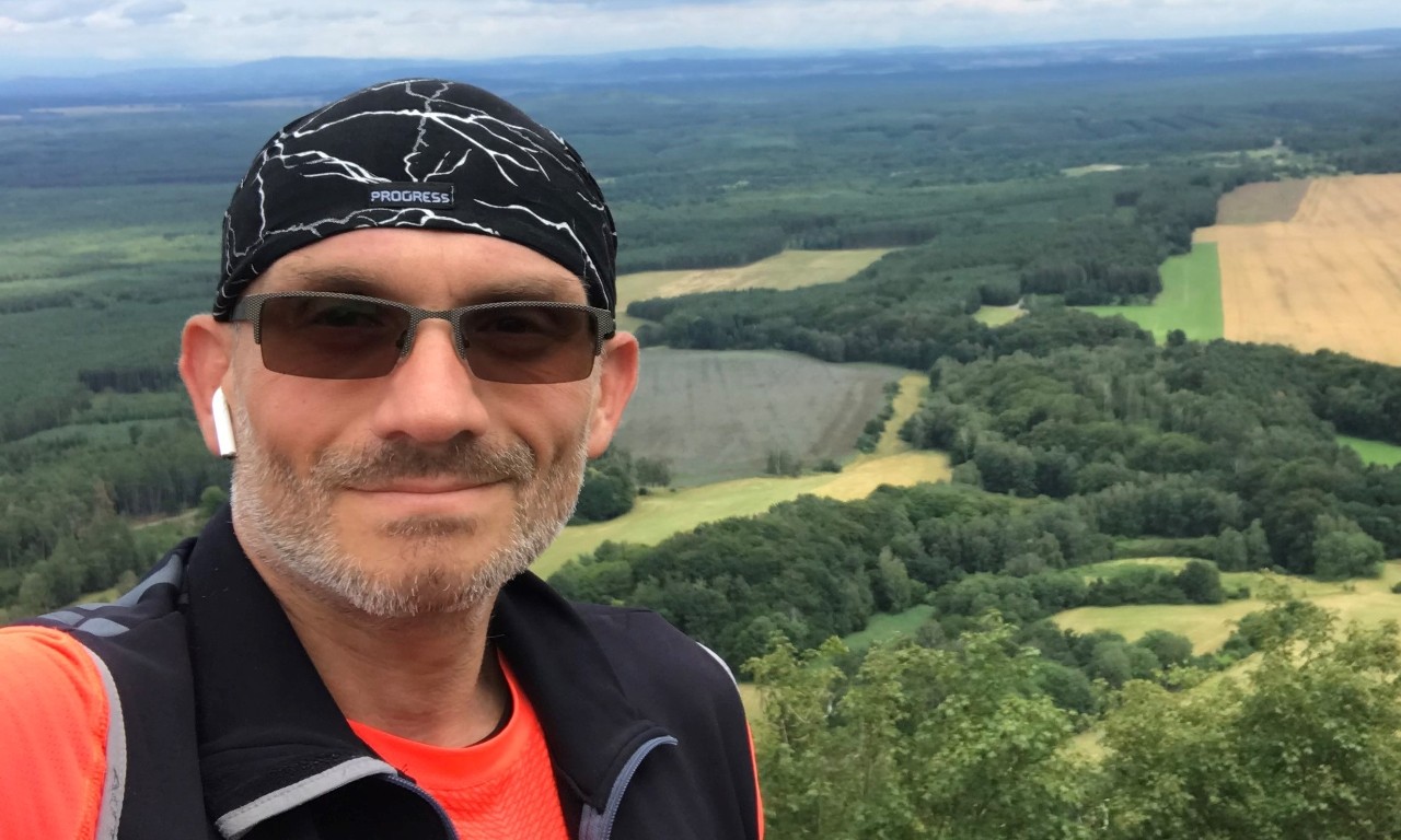 Man in nature taking a selfie, smiling at camera